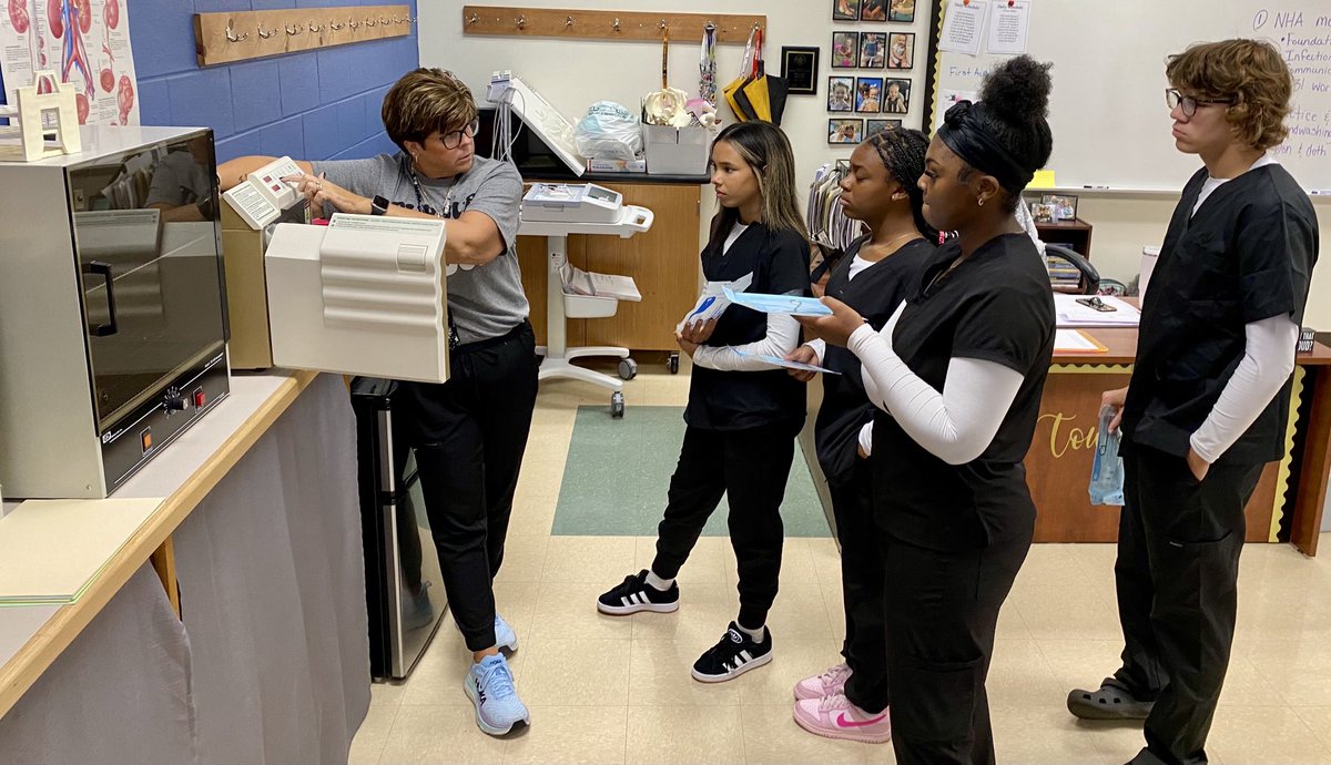 Mrs. Townsend is teaching Medical Assistant students the steps in using the autoclave. Students then practice using it.