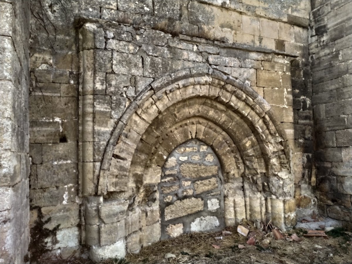 La antigua portada románica del templo de S. Saturnino en Rioseras se encuentra en estos momentos medio escondida por el suelo. Pero aún se pueden apreciar las arquivoltas, ligeramente apuntadas, con decoracion en ajedrezado y tacos.