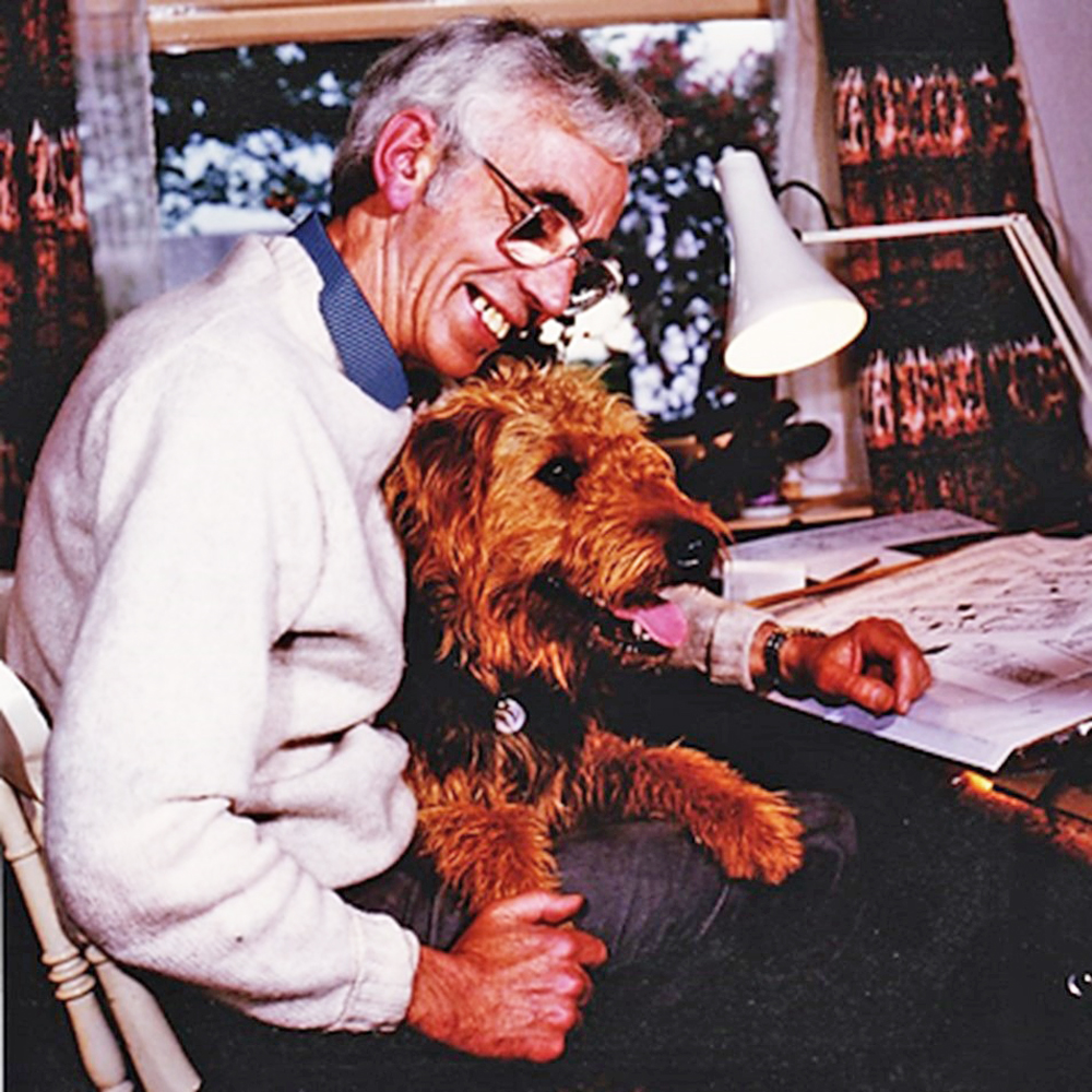 Ewen Bain, the creator of the Angus Og cartoon strips which appeared for many years in the 'Daily Record', at his desk with his dog, Barney. Two complete Angus Og strips are now available on Am Baile with more on the way - ambaile.org.uk/angus-og/