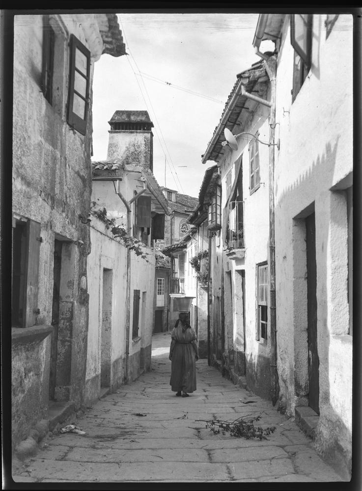 Muller nunha rúa de Tui.
📷 Otto Wunderlich, c. 1930.
"Naqueles longos invernos de infancia, a luz era moitas veces de tebra. Luz de Tebra era a denominación popular daquela luz esmorecida, derivada do lugar de onde viña a corrente: o val de Tebra".
🖊️Ánxel Vázquez de la Cruz.