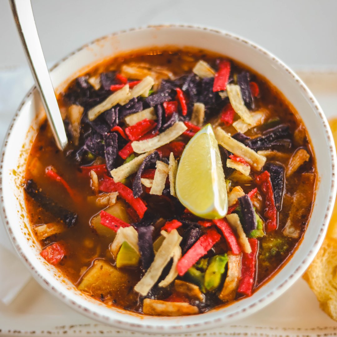 TulasKitchn's tweet photo. Have you tried our Green Chile Chicken Stew? It's packed with hearty flavors and topped with crispy tortilla strips, fresh avocado, and a squeeze of lime. Perfect for when you need a little comfort with a kick! https://t.co/LQqFZQjgXK