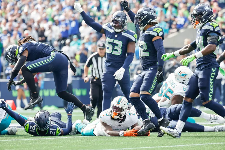 The Seahawks held the Dolphins to:

1 for 12 on 3rd down conversions
0 for 3 on 4th down conversions

That's the first time that has happened in the history of the NFL.