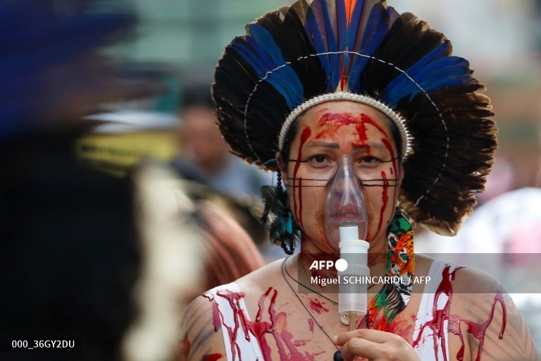 A Brazilian indigenous woman wears a portable oxygen mask during a march for climate justice and against wild fires affecting the entire country in Sao Paulo. 
📸 Miguel Schincariol #AFP