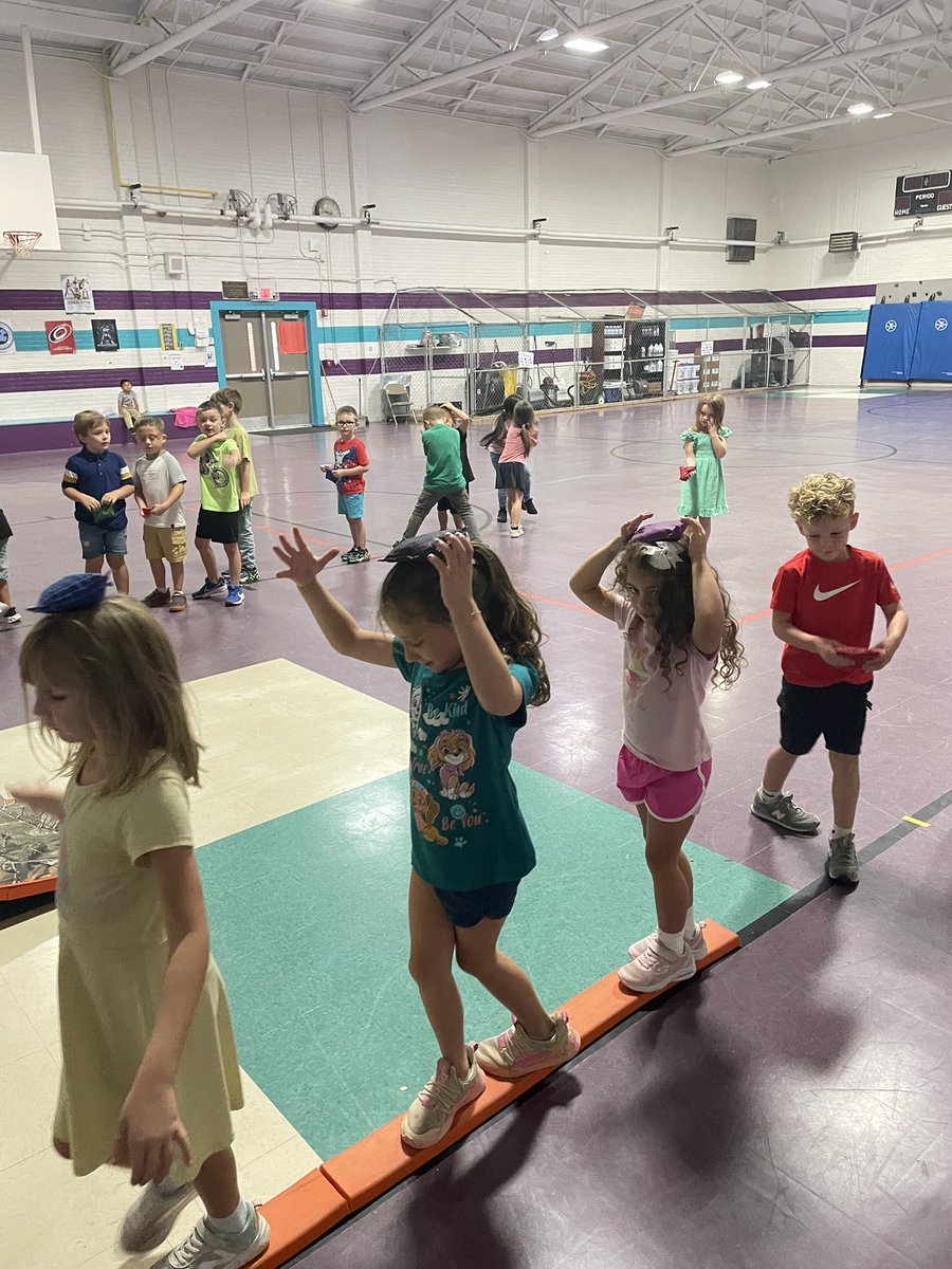 Beanbags on head on balance beam.