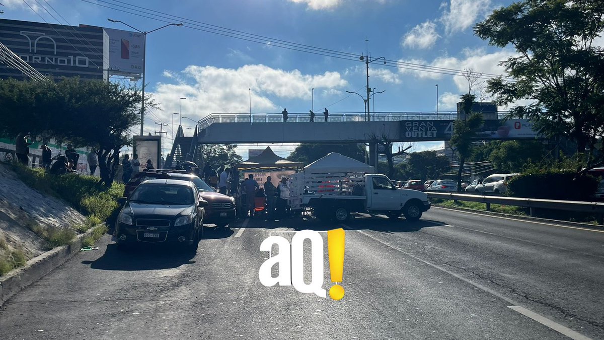 AlertaQro's tweet photo. #AlertaSucesos | 🚨🚨Autoridades liberan un carril a la circulación en el Boulevard Bernardo Quintana, a la altura de Las Américas. Los manifestantes aún mantienen dos carriles bloqueados en dirección a Paseo 5 de Febrero.

Las personas piden que se resuelva a su favor un litigio que tiene muchos años en el que exigen un pago porque dicen que el Boulevard Bernardo Quintana fue construido en tierras de su ejido.