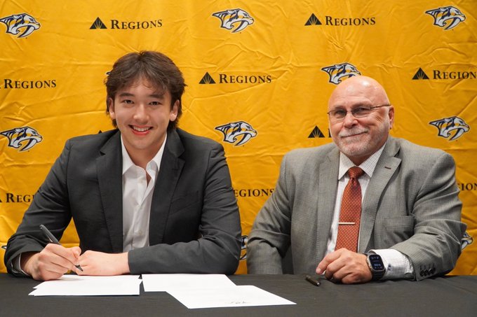 Photo of Hiroki Gojsic and Barry Trotz smiling as Hiroki signs his entry level contract.