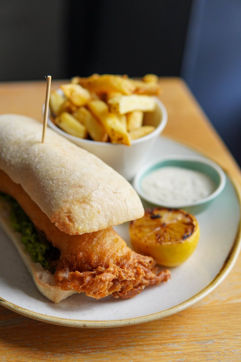 Now THAT is a "Fish Finger"! This delightful play on a classic currently features on our lunch menu - crispy golden, beer-battered fish, served with tangy homemade tartare sauce, buttery mushy peas, and triple-cooked chips. #GoneFishin 🐟