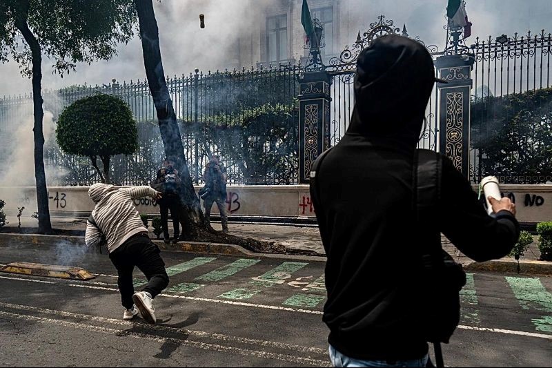 SomosProceso's tweet photo. En el marco de los 10 años de la desaparición de 43 normalistas de Ayotzinapa, un grupo de estudiantes lanzó explosivos a la Secretaría de Gobernación en una acción relámpago. Foto: Félix Márquez / AP https://t.co/IPeSOFDS2A