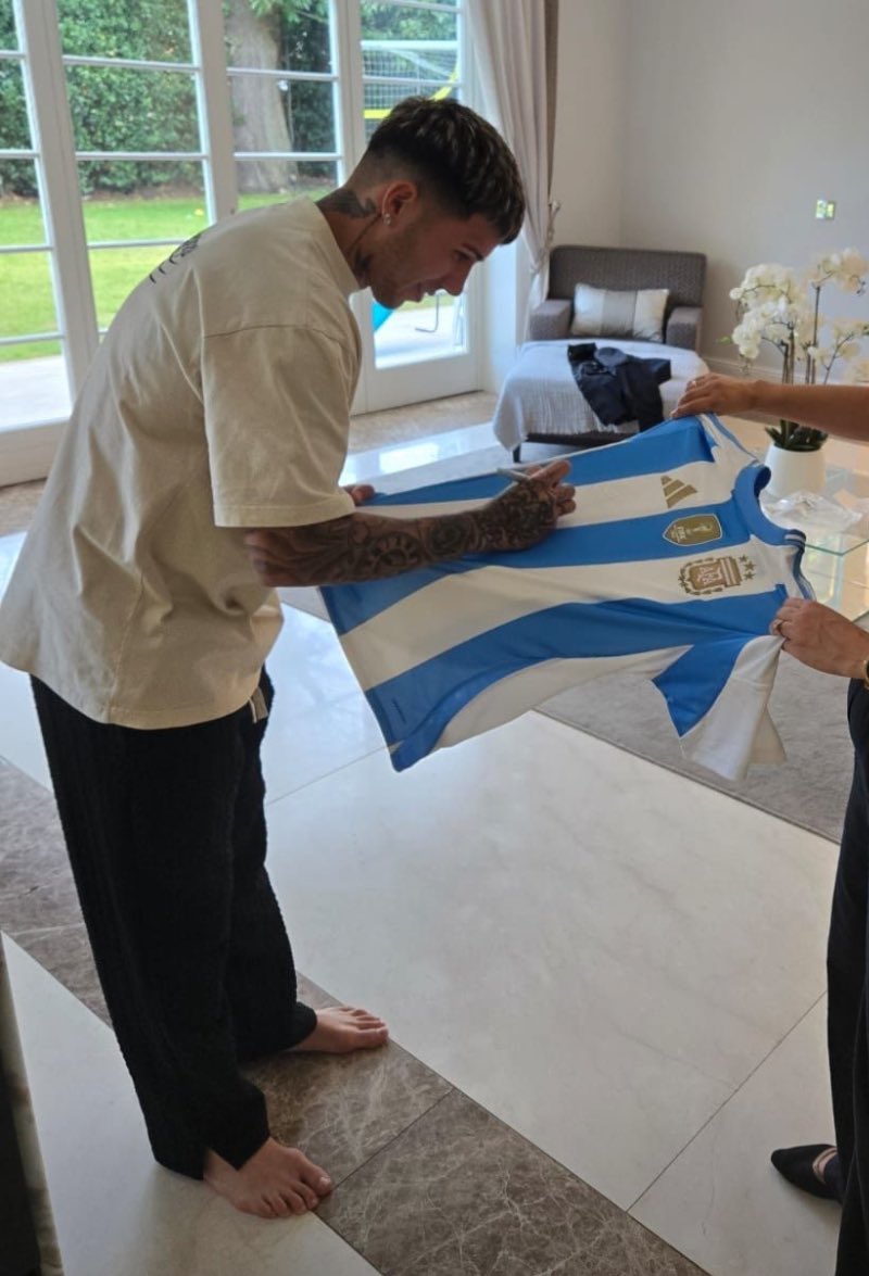 Enzo Fernández firmando una camiseta de la Selección Argentina, uno de los tantos premios que serán subastados el viernes 27 de septiembre en el evento de <a href="/AngloArgentineS/">The AngloArgentine Society - AAS Since 1948</a> y <a href="/APARU_UK/">APARU</a>.  La recaudación se destinará a realizar obras de beneficencia.