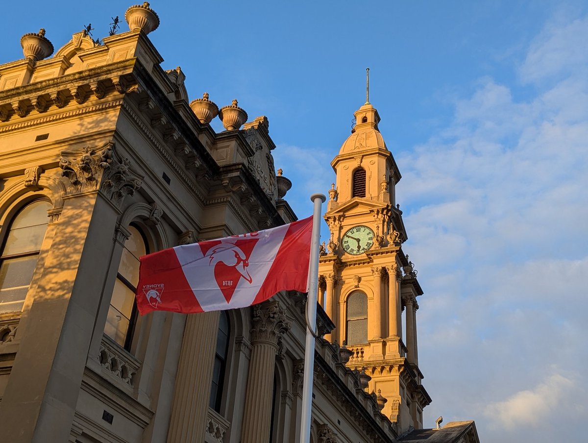 PeteKelson's tweet photo. As the sun sets on South Melbourne Town Hall, the Swans flag flies in our ancestral home @sydneyswans https://t.co/t1N5p7zMDj