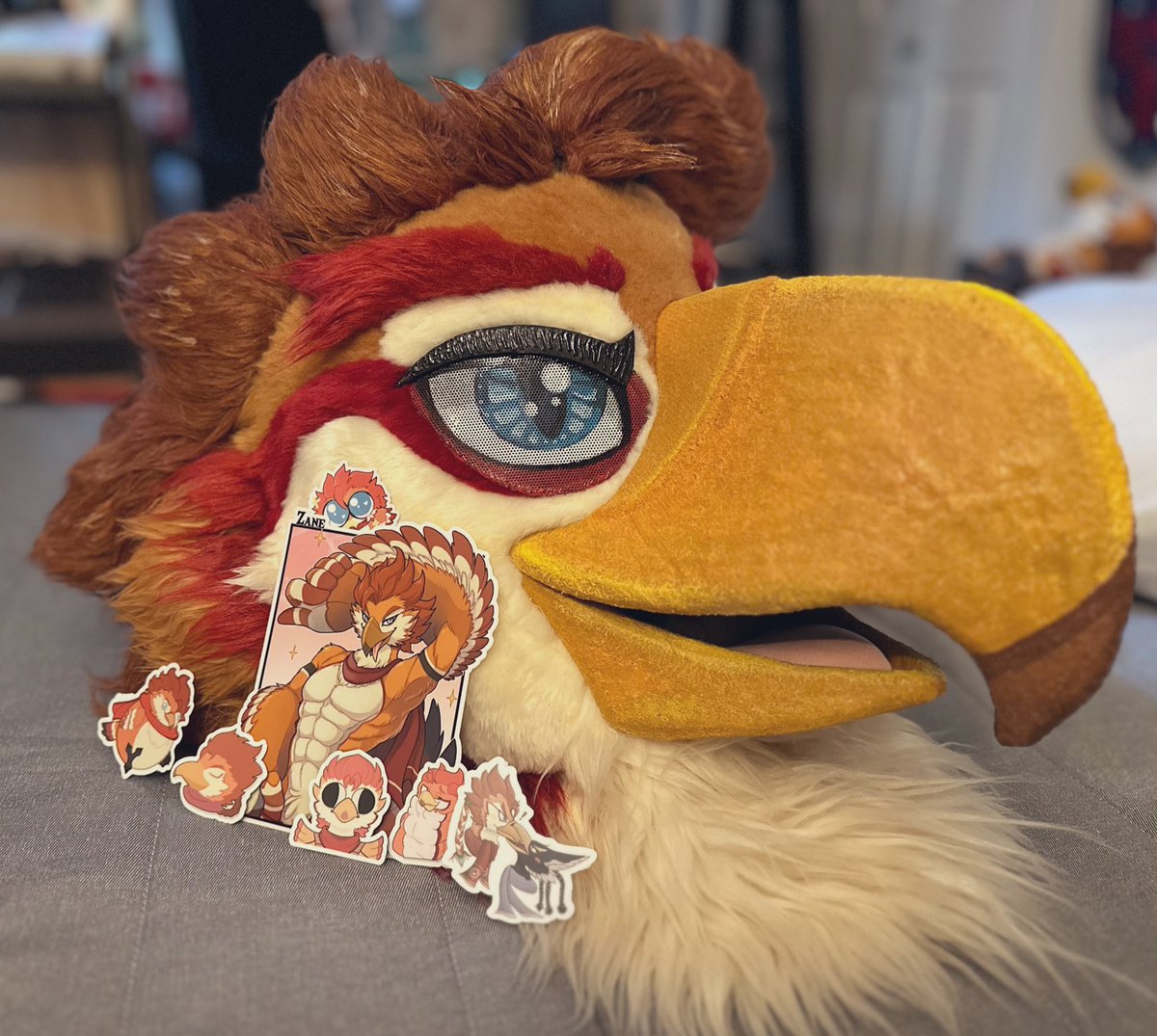 Coming soon to a furmeet or convention near you! 👀

If you happen to catch me during my adventures, be sure to ask one or all of these ✨STICKERS✨(presented by my smug mug for scale)

Thank you <a href="/BurdPrints/">BurdPrints</a> and Vinyl Disorder for making my current inventory possible~