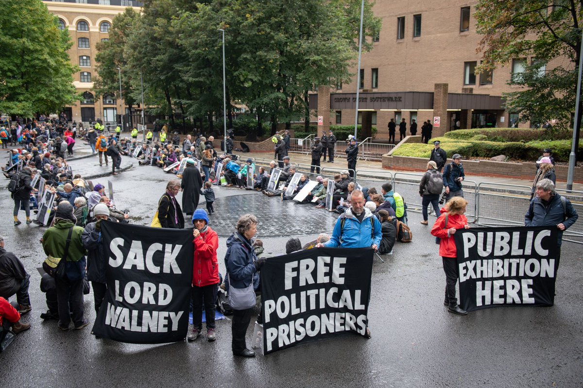 GreenFuture4All's tweet photo. Over 300 sat outside the Court holding an exhibition of current &amp; historical political prisoners. The streets were lined with police vans in case we did anything other than the most inoffensive protest. Solidarity with #JustStopOil ✊️🧡 #DefendOurJuries #FreePoliticalPrisoners https://t.co/Vsy4OygfVO