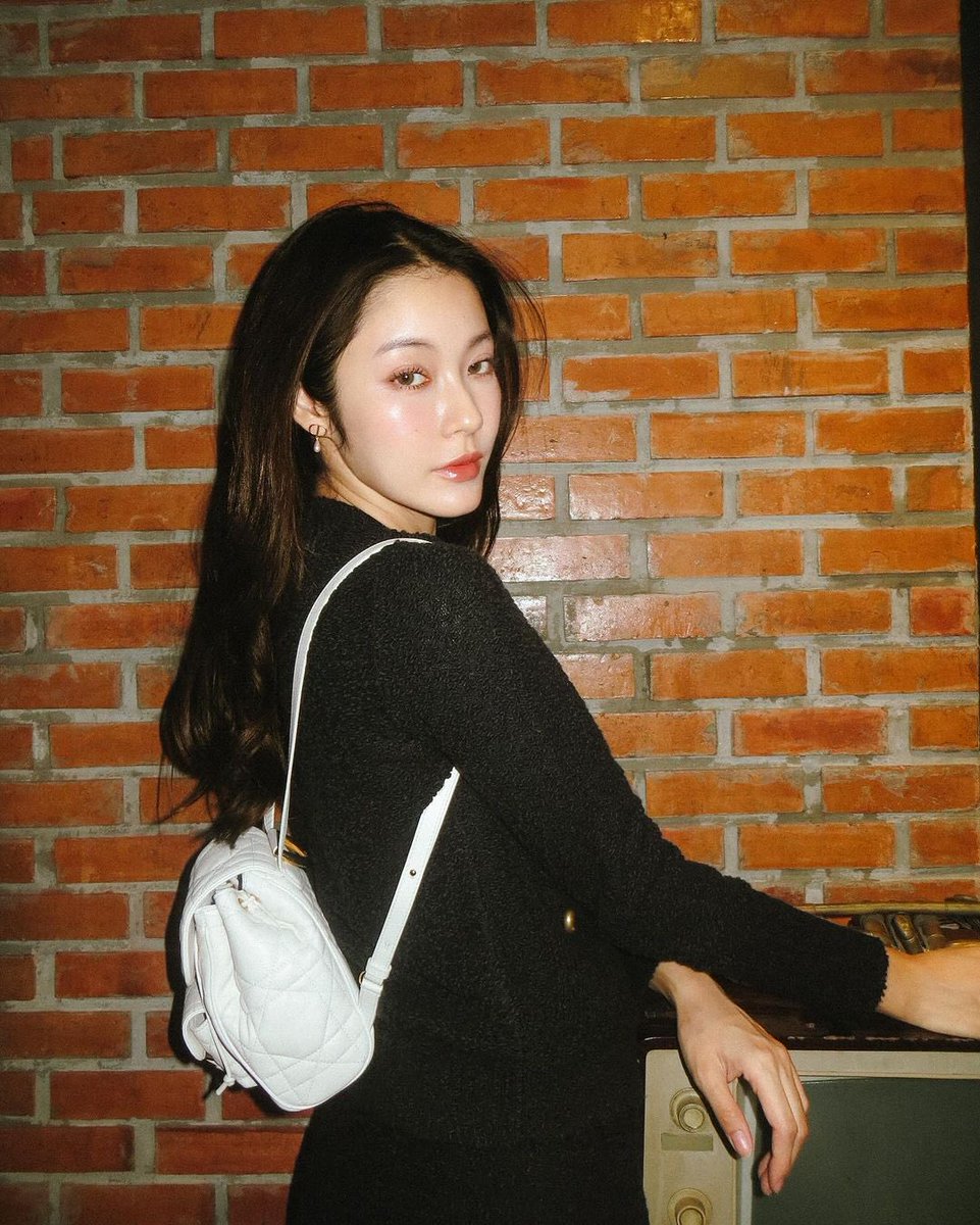 Striking contrast to dark outfit and completing the polished yet casual aesthetic provided by a white quilted backpack hangs delicately, 𝐃𝐢𝐨𝐫 #𝐃𝐢𝐨𝐫𝐒𝐒𝟐𝟓.