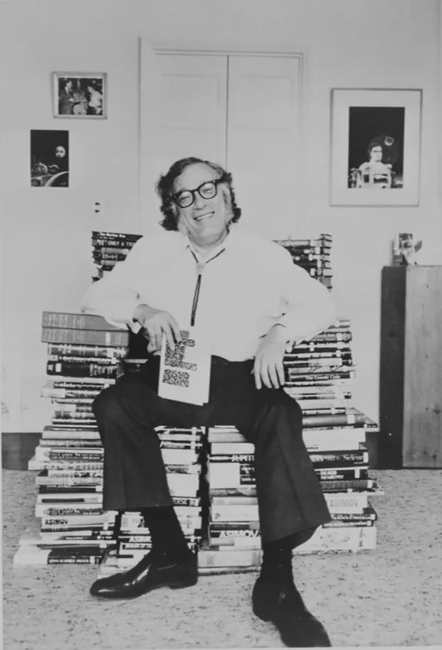 Writer Isaac Asimov sitting on a throne of every book he ever wrote. Over the course of his life, he wrote over 500 books and 380 short stories