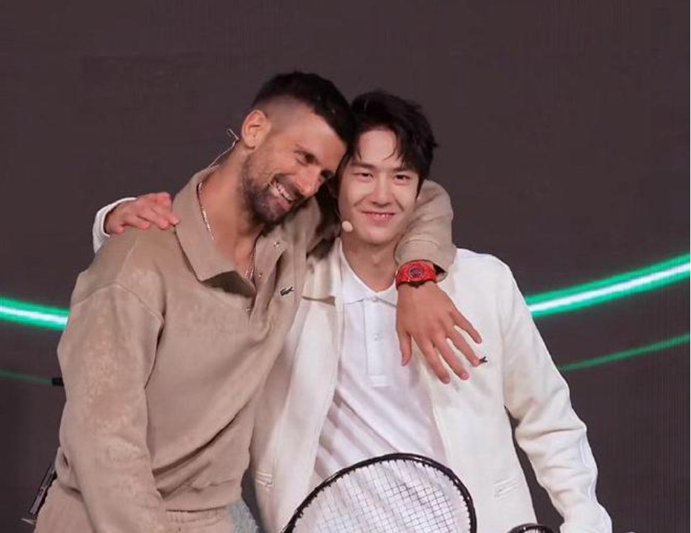 shanghaidaily's tweet photo. 🎾🌧️ In a Sunday #Lacoste streaming event in Beijing, #WangYibo teamed up with tennis legend Novak Djokovic! Despite the rain, Yibo scored 3 points while Novak kept cheering him on. 🙌 After the match, Novak even challenged Yibo to a rematch at the next #LacosteDryOpen! 👀🔥

Fans say they can’t get over how cute they were playing in the rain! 🐊❤️

#WangYibo #NovakDjokovic #TennisOnTheWall #GreatWallEvent #SportsFashion #LacosteStyle #IconicDuo #TennisInTheRain #王一博
