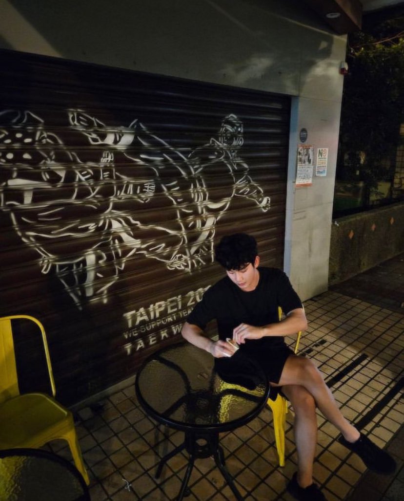 DOGNWON's tweet photo. Underneath the neon whispers, a shadow bends against the yellow chair. Folded like crumpled letters left unread, between the ripples of glass-topped solitude. https://t.co/bKZPhxUVIm