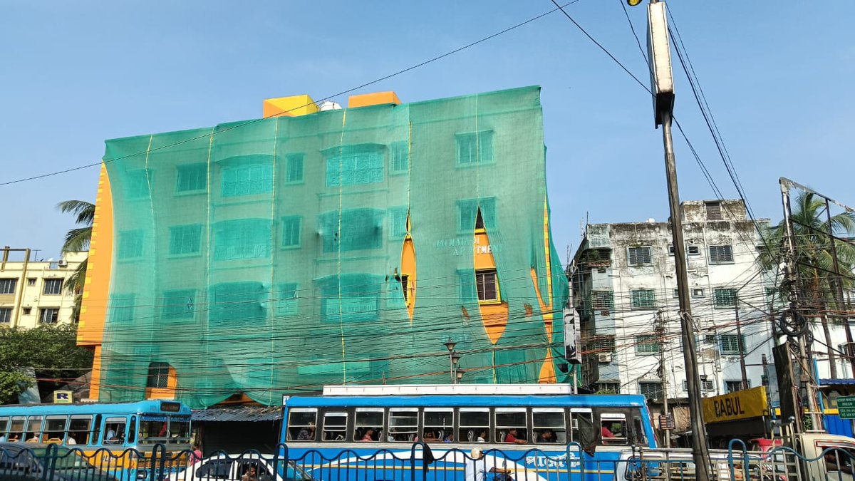 SuvenduWB's tweet photo. So the colour Saffron is an eyesore for the CM !!!

A building near the Kolkata Airport which was painted in Saffron colour was forcefully covered by Green Net by the Mamata Police and local Municipality Officials so that the CM who was returning back from North Bengal doesn't get annoyed.

It's unfortunate that the colour Saffron; a symbol of Valor which also signifies sacrifice and salvation, worn proudly by Swami Vivekananda, makes the CM uncomfortable. 

The name of the building is 
Joy Mata Di Apartment owned by Shri Panna Bardhan.

The colour of the Sun at dawn paints the whole sky Saffron, what would the Administration do to cover that?