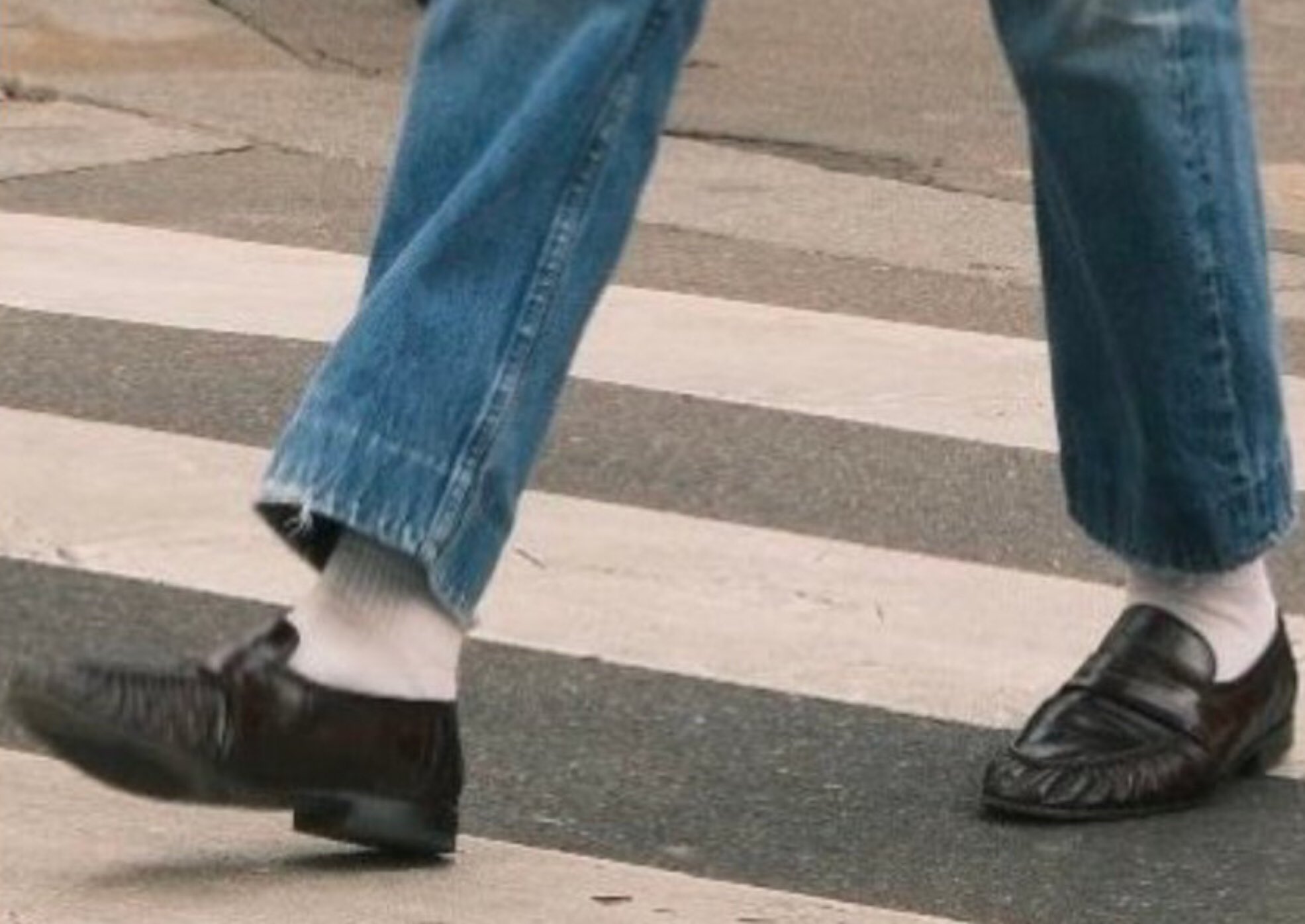 Cropped blue jeans, a cream crew sock, and brown loafers on a city crosswalk, a 2026 fit-check crop posted on X