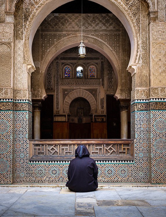 Man seating at the courtyard of the Al Attarine Madrasa. Fez, Morocco 🇲🇦