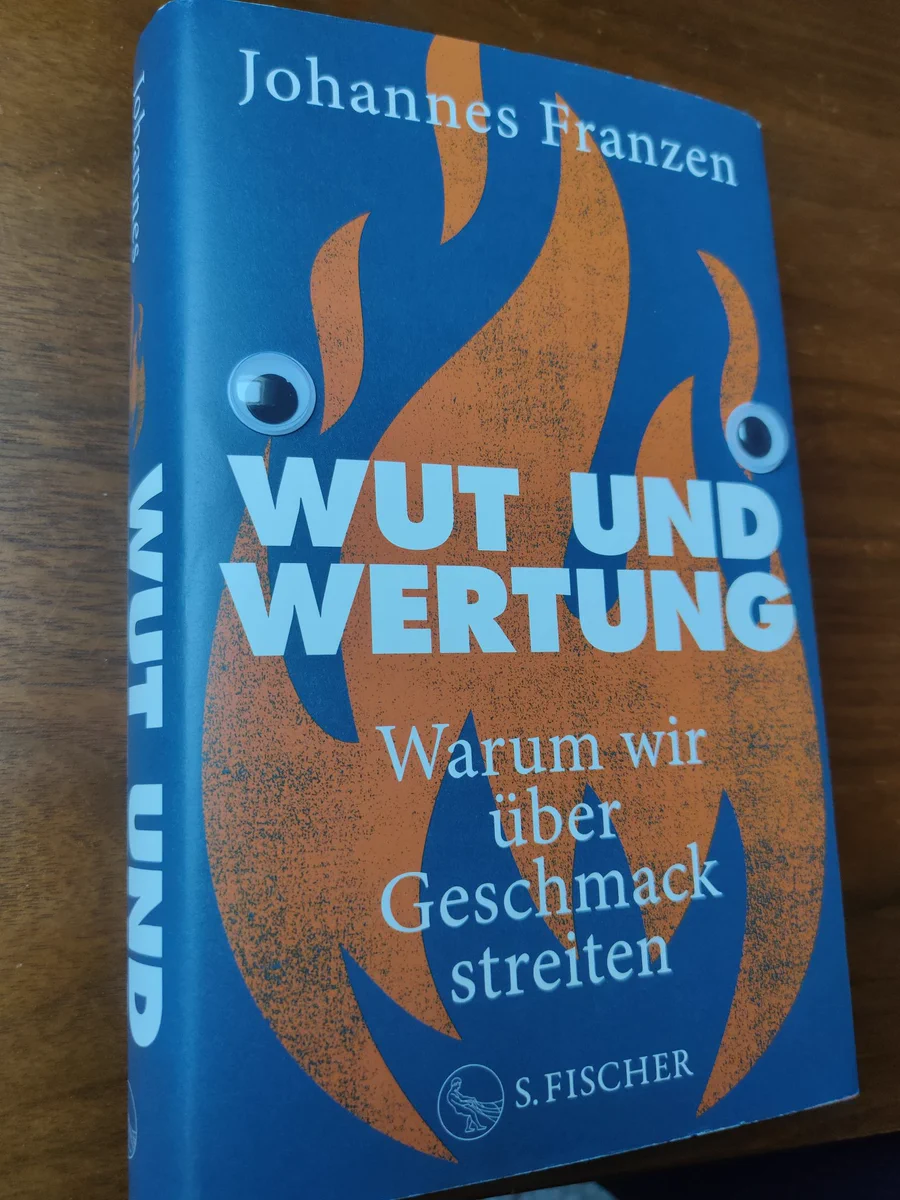 Ein Foto von Johannes Franzens Buch "Wut und Wertung". Darauf wurden Bastelaugen gelegt