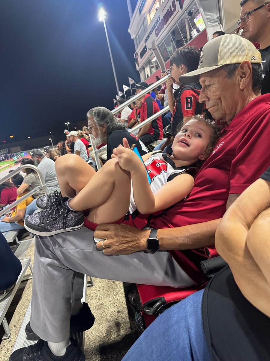 My new job in retirement, being a stadium seat for my granddaughter.