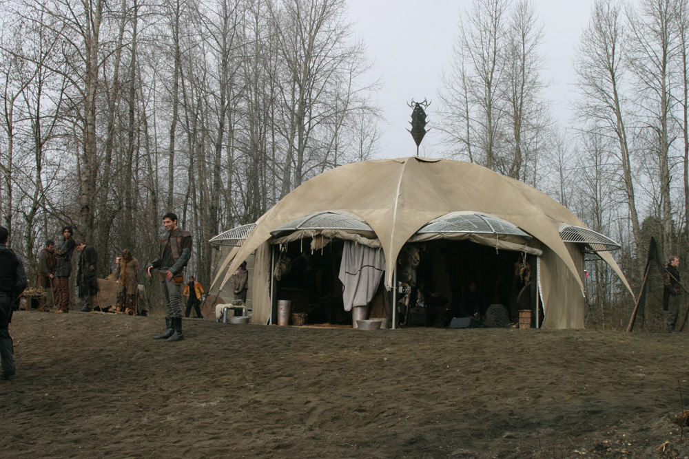 platschu's tweet photo. This promotional picture of the Atlantis 1x01 Rising shows this tent which got the Jaffa symbol of Ba'al on the top. Was it meant as an easter egg? It can be hardly seen in the episode, but you can check it around 39:32. #stargate #WeWantStargate @bradtravelers @AmazonMGMStudio https://t.co/zmw8J2qZSt