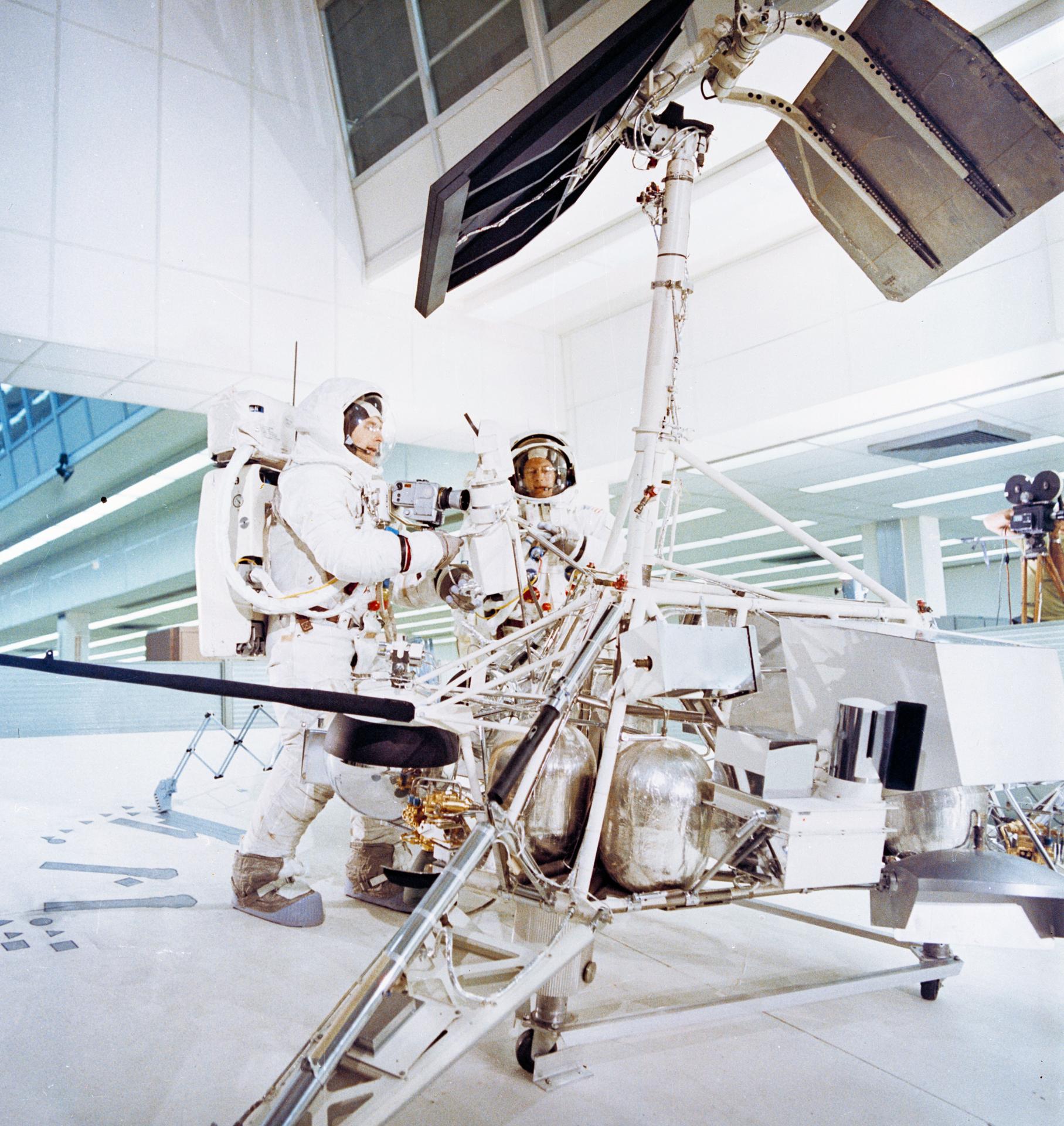 Astronauts Charles "Pete" Conrad Jr. (right), commander; and Alan L. Bean, lunar module pilot, simulate a photographic inspection of the unmanned Surveyor 3 spacecraft in Kennedy Space Center's Flight Crew Training Building. The inspection of Surveyor 3, which had been resting on the moon's Ocean of Storms since April 1967, is an important objective of the Apollo 12 mission. Selected pieces were cut from Surveyor 3 and brought back to Earth for scientific examination.