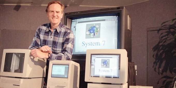 a photo of John Sculley standing behind 3 Macintosh computers.