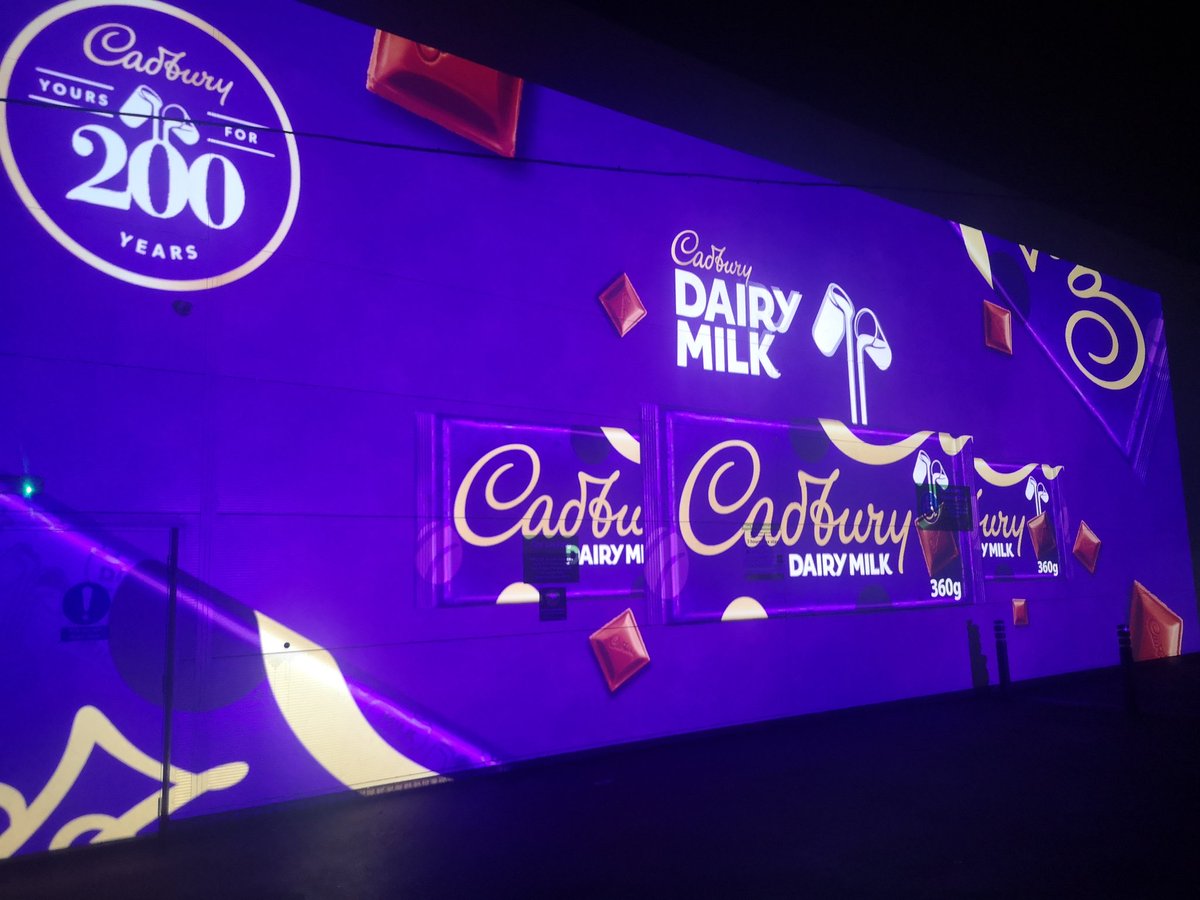 FoxOnFilms's tweet image. My @asda has 2 huge digital projectors in the car park. Tonight they went live &amp;amp; are now screening a promo ad for @CadburyUK. As a film historian I can tell you that this is exactly how motion picture ads started out before cinemas, just projected on the walls of buildings.