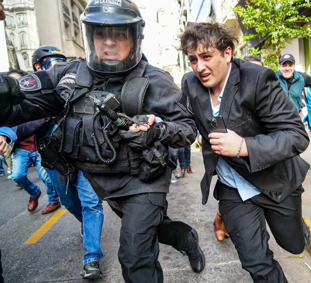 El corrió de la mano de un policía uniformado