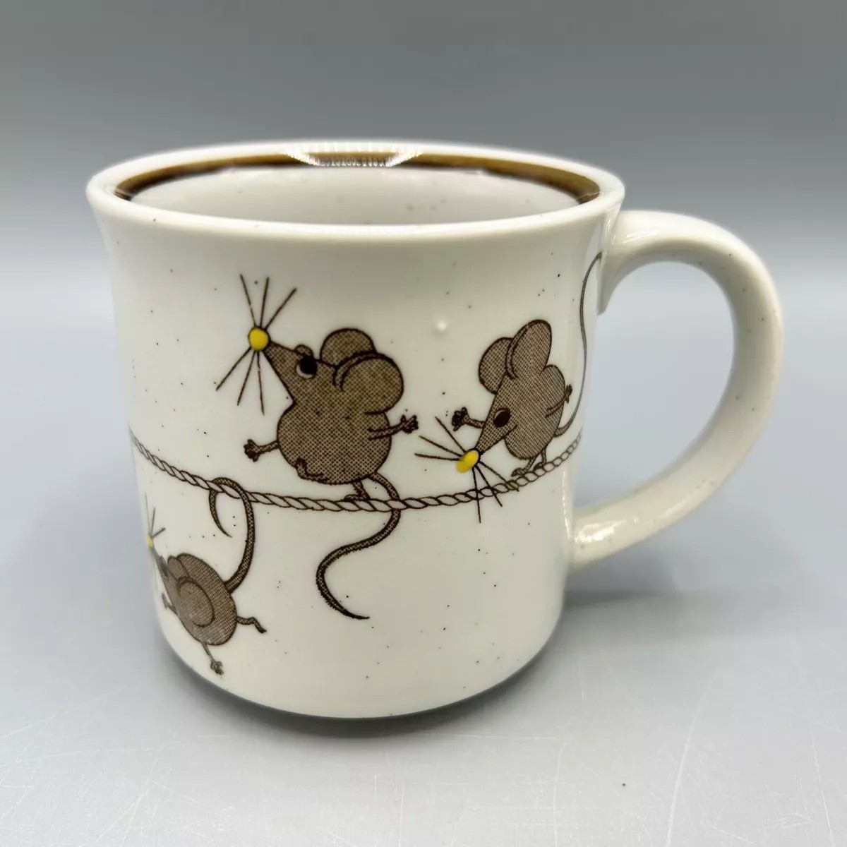 Very adorable mug showing a line of mice in various poses balancing on or hanging from a tightrope. 