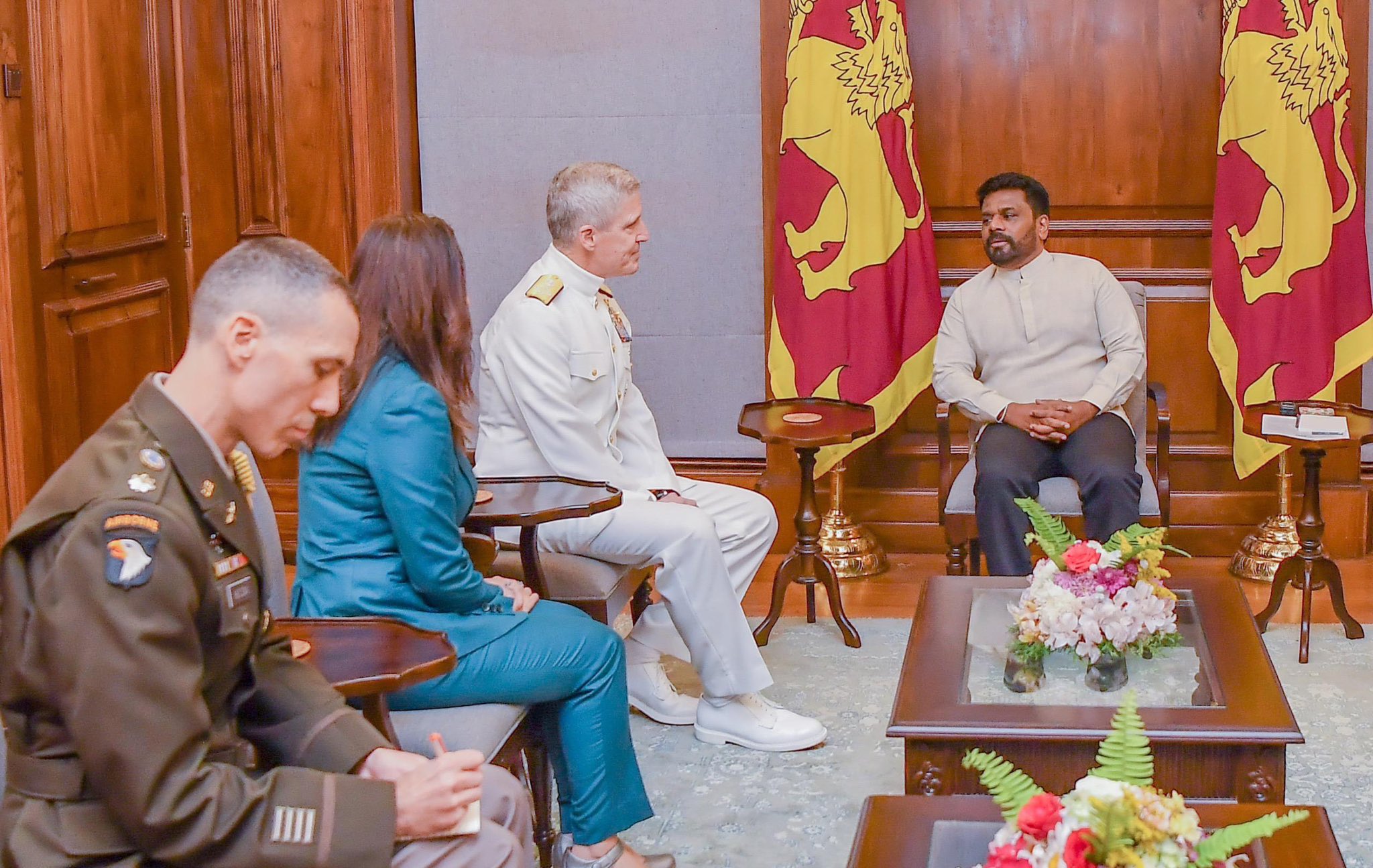 Ambassador Chung, Admiral Koehler, and Sri Lankan President Dissanayake sit and talk in a room with flags. A note taker sits to the side.