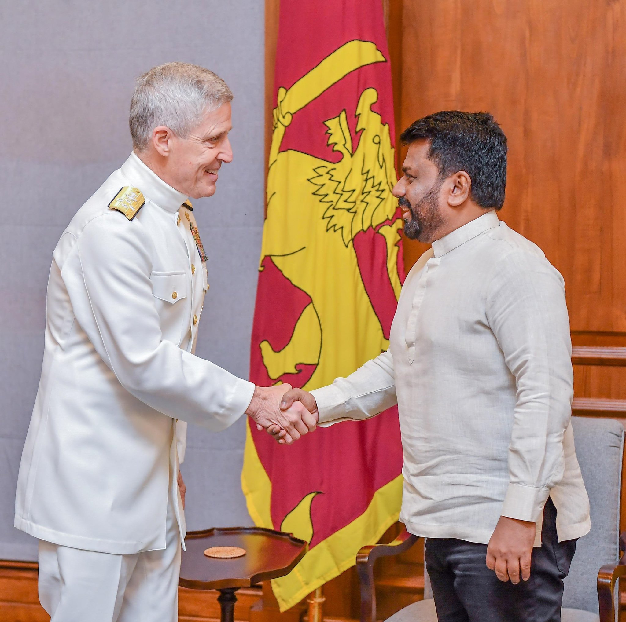 Admiral Koehler and Sri Lankan President Dissanayake shake hands in front of a flag.
