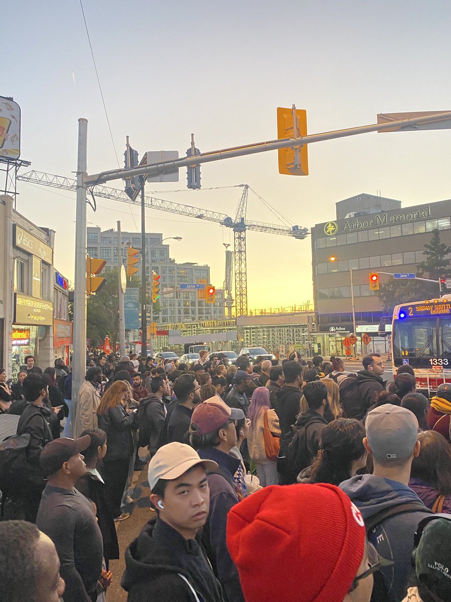 johnadtory's tweet photo. This is what @TTCnotices calls “minor delays” as all #TTC subway service is stopped at Jane. Hundreds of people on the sidewalk waiting for… four replacement buses. FOUR. No traffic management. No staff in the red aprons to help. No designated safe area to wait. four buses. https://t.co/VrPv5wx2Sf