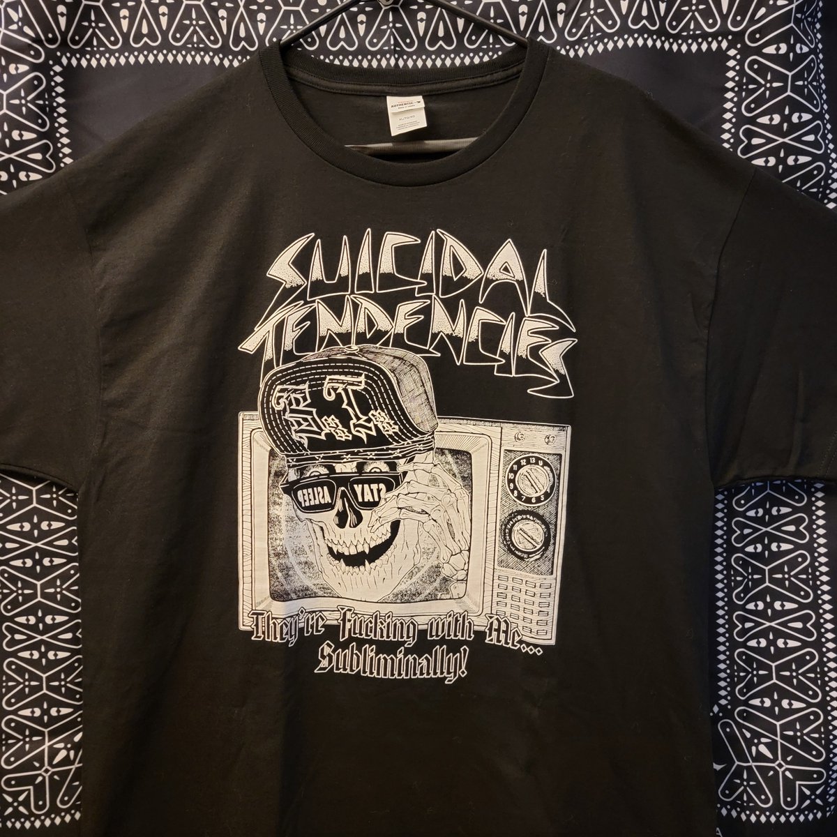 OFFICIALSTIG's tweet image. Our newest Artist Series drop brings you Tom T-Bone Edwards' interpretation of "Subliminal".
The front pays homage to a classic 80s movie and the back hides a bunch of subliminal Revealed only under a UV light.
It's Propaganda Subliminally!
Available  NOW!
suicidaltendenciesstore.com/products/tste-…