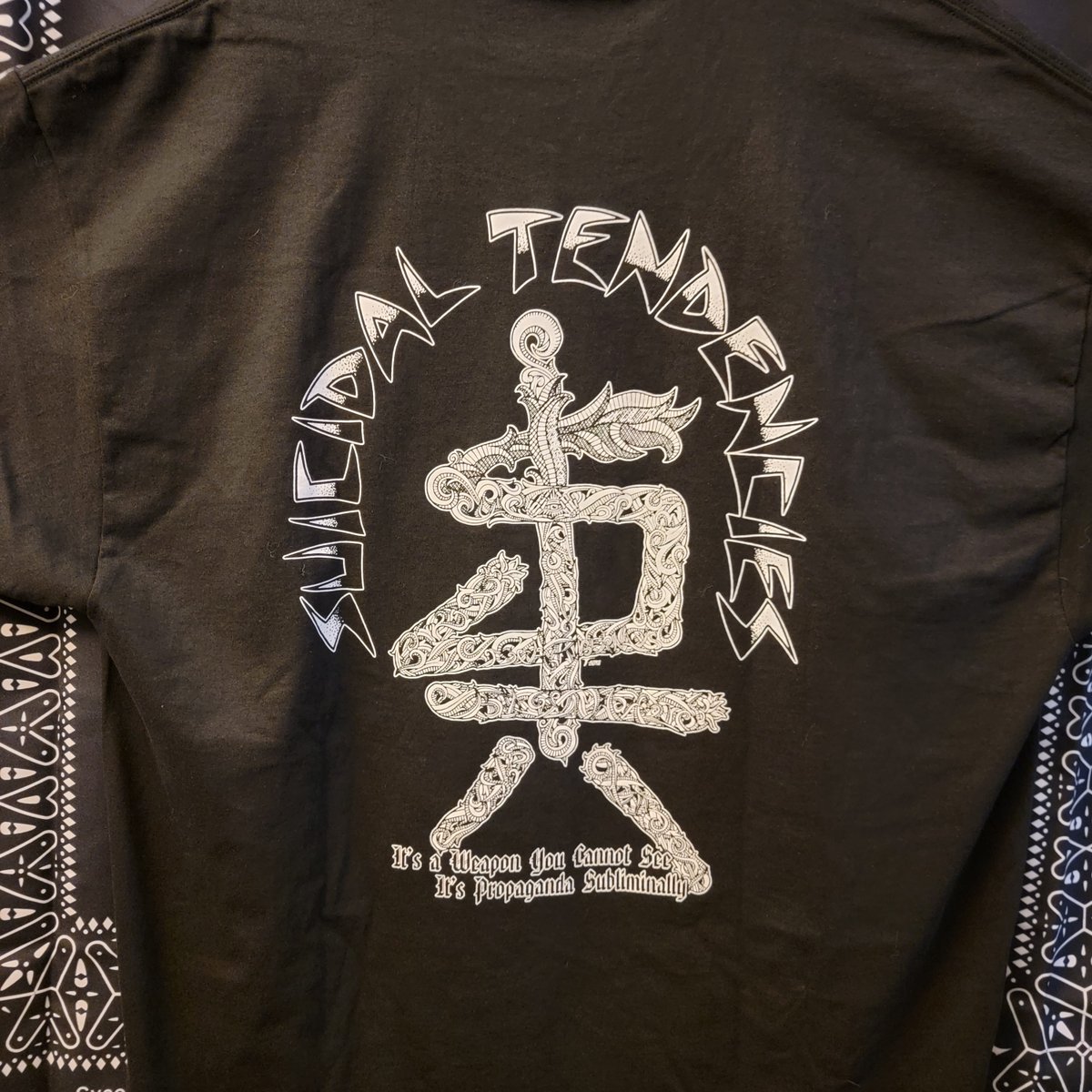 OFFICIALSTIG's tweet image. Our newest Artist Series drop brings you Tom T-Bone Edwards' interpretation of "Subliminal".
The front pays homage to a classic 80s movie and the back hides a bunch of subliminal Revealed only under a UV light.
It's Propaganda Subliminally!
Available  NOW!
suicidaltendenciesstore.com/products/tste-…