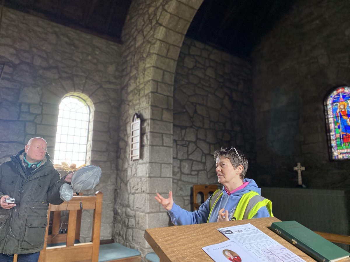 Pilgrim Guide Elaine Kelly speaks to pilgrim German radio reporter Peter about St Patrick at Saul Church