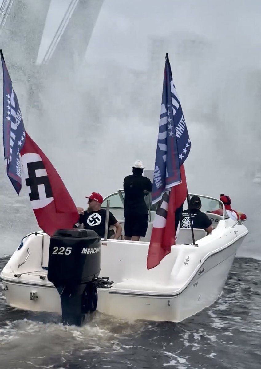WUTangKids's tweet photo. Eric Trump at one of those dumb Trump boat parades they do in Jupiter, Florida and a casual Nazi boat https://t.co/15ZjaaOCPL