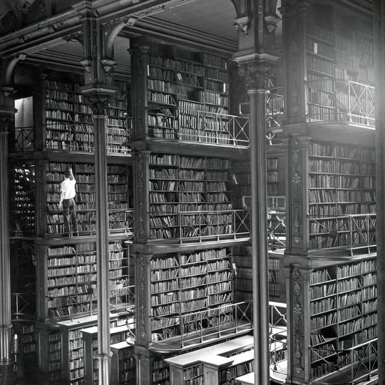 A man browses for books in the old Public library of Cincinnati. The building was demolished in 1955. Today an office building and a parking lot stand where it used to be.