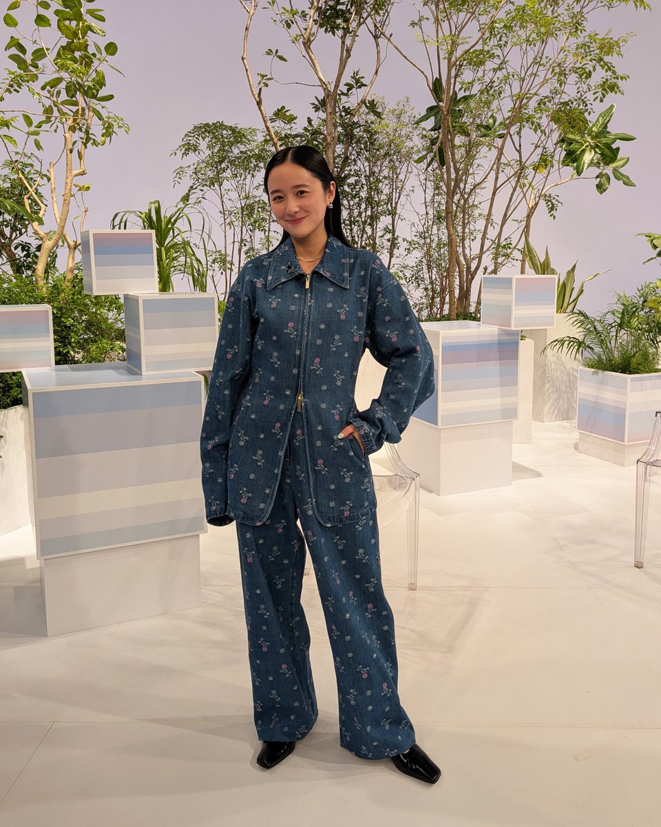 小花柄付きのデニムセットアップ。柔らかな笑顔とポーズでそこだけ春が