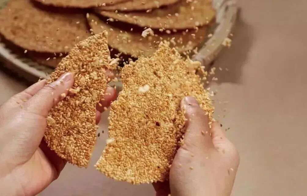 淄博的周村烧饼，也为山东年俗添了别样风味。
“形如满月，薄似秋叶；落地珠散玉碎，入口回味无穷。”过年走亲访友时递上一包周村烧饼，便是一份“圆满”与“响亮”的祝福。