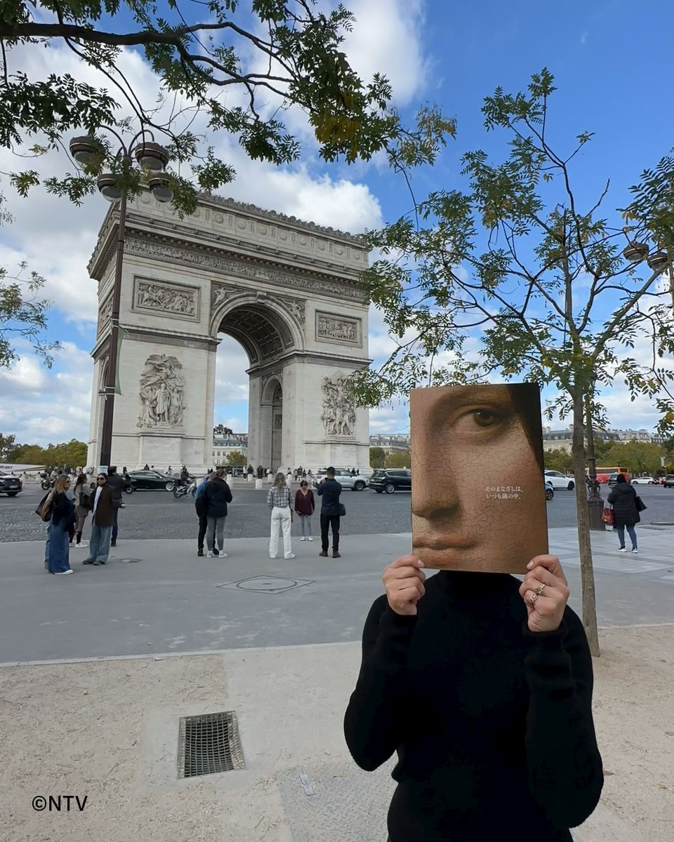 シャンゼリゼ通り、凱旋門を背にした謎の女性。 そのまなざしは