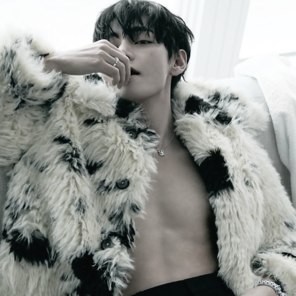 Toehynug's tweet image. Snow-dappled fur that clings like winter's wild whisper to bare skin, a figure reclines with effortless dominion—midnight strands tumbling across a gaze half-lidded in quiet reverie, fingers adorned in Cartier's crystalline gleam tracing the edge of parted lips as if savoring.