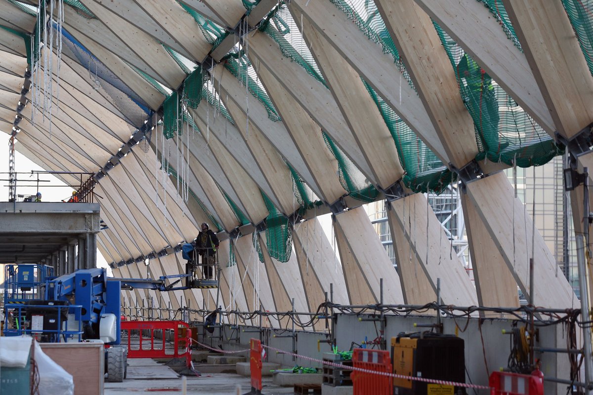 capbcon's tweet image. London built a major railway station inside a dock — and covered it with timber.

The Canary Wharf Elizabeth Line Station sits inside the former North Dock, constructed as a 300 m-long concrete box sunk into water, then capped with a ~4,500 m² laminated timber roof made from…