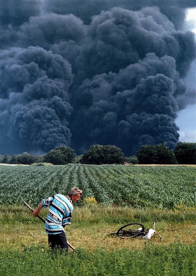 A farmer continues working as NATO bombs Yugoslavia, 1999.