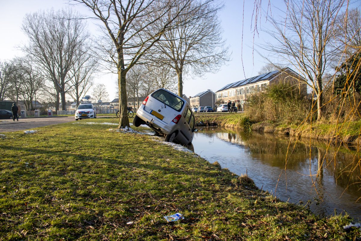Auto belandt boven sloot in Sneek; Bestuurder gevlucht