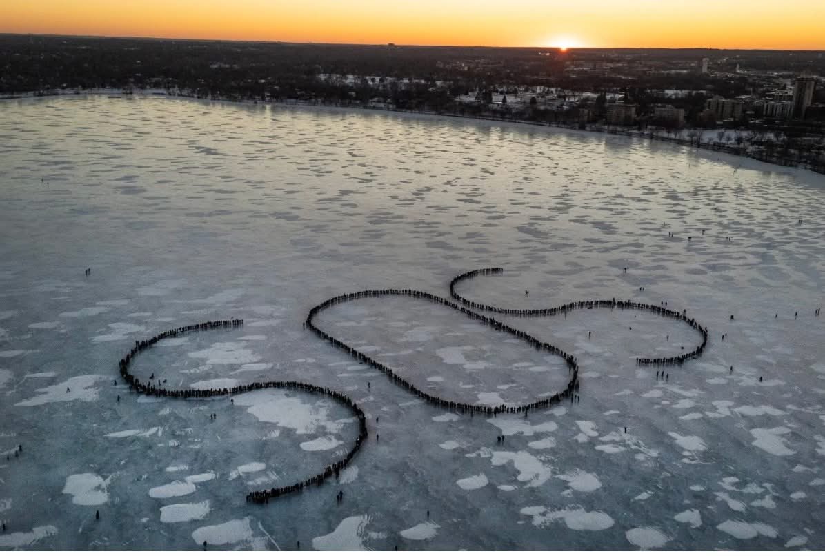 Amy_Siskind's tweet image. Hundreds of people stand on a frozen lake in Minneapolis in a formation that spells out “SOS” in protest of ICE.
(Credit: David Guttenfelder/NYT)