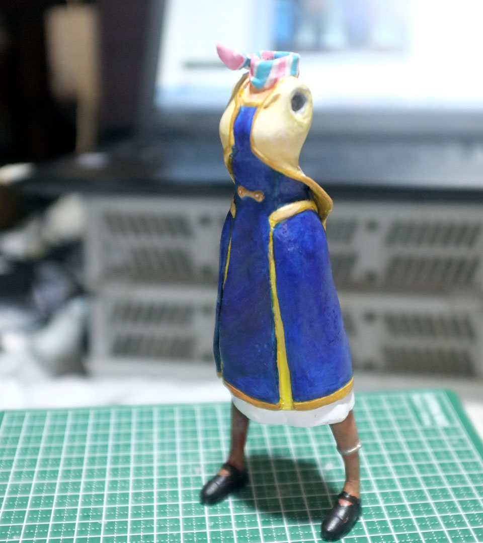 髪にアクセントをいれて感じをみてから、まつ毛と瞳をいれます。はかどらないです。
服・・上着は白と甲板色の混合色・ボタンとモールは独断で渋い金色に。
スカーフは思っていたより楽でした、明るい色は白で隠蔽(いんぺい)しやすいので・・

#アポカリプスホテル #自作フィギュア