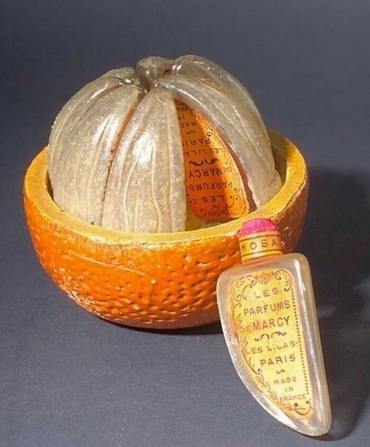 An antique perfume bottle shaped like an orange early 1900s French design where fragrance met art.