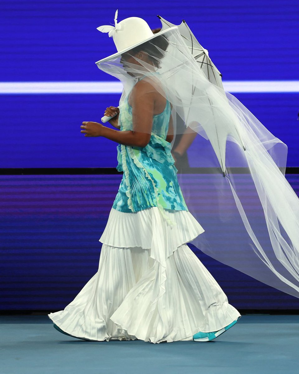 UniversTennis's tweet photo. L’entrée de Naomi Osaka, double championne à l’Open d’Australie, sur la Rod Laver Arena. 🤍☂️

📸 @WTA https://t.co/wpzJ5lZqH5